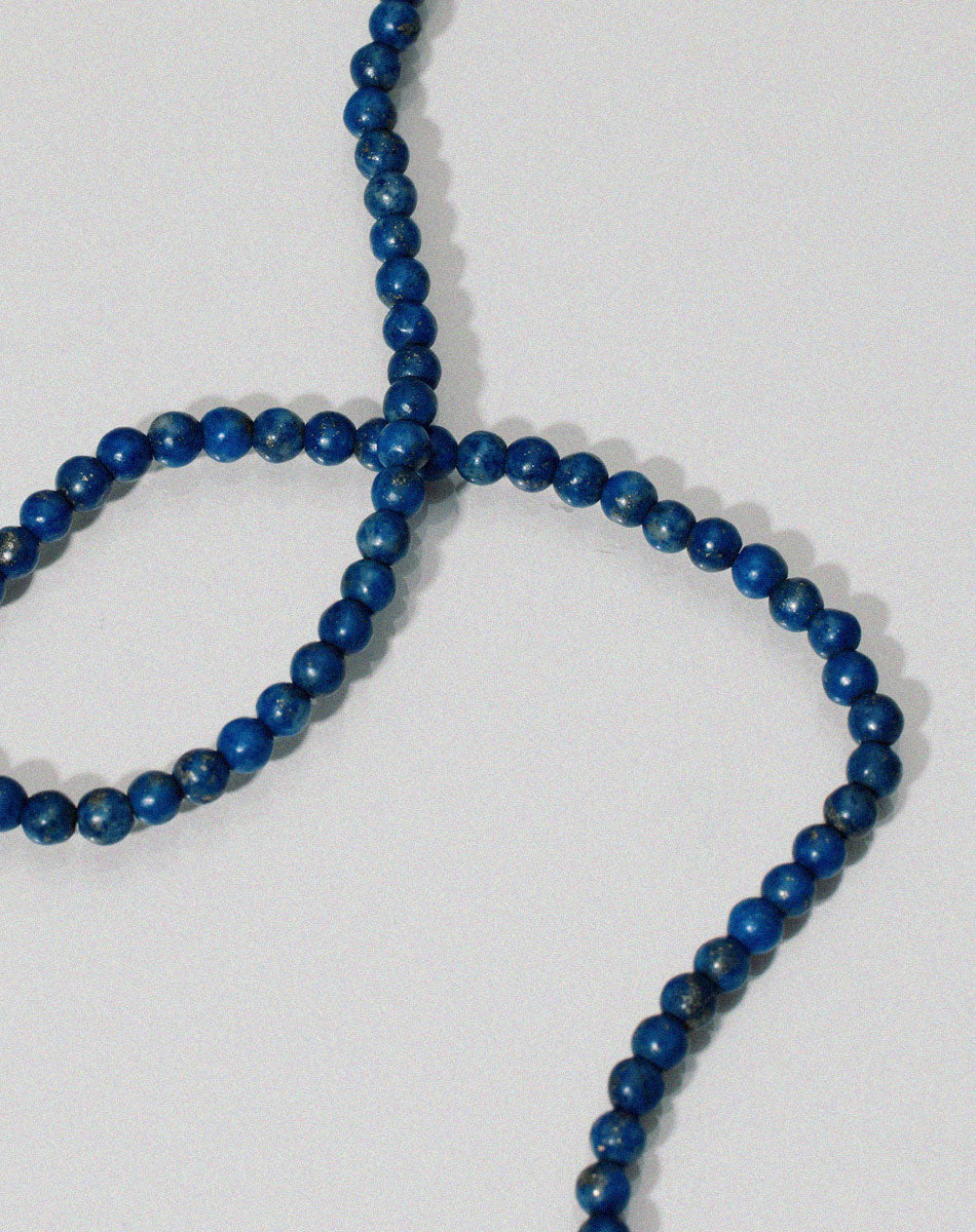 Small spherical lapis lazuli stone beads anklet on textured background